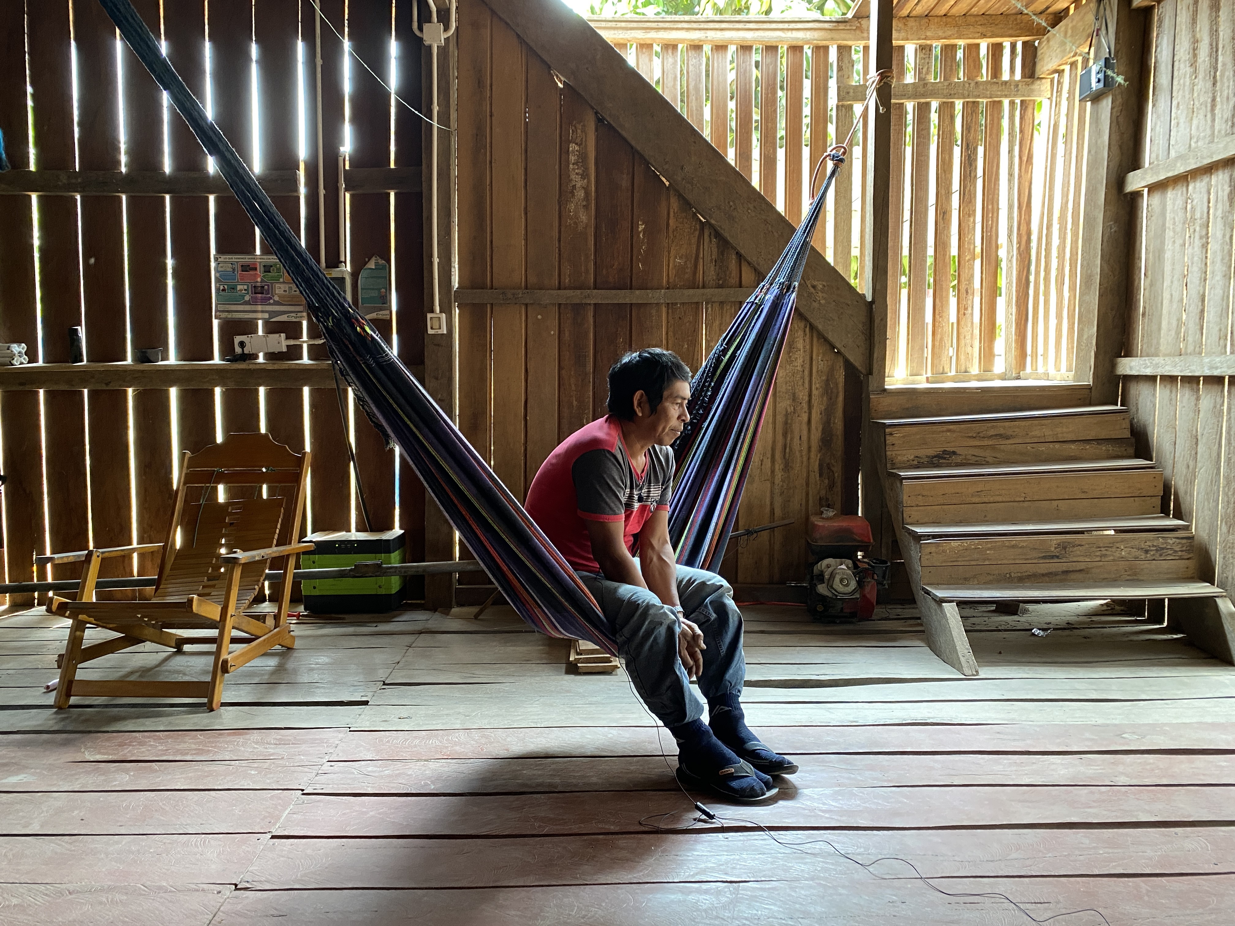 man sits on hammock in house in peru