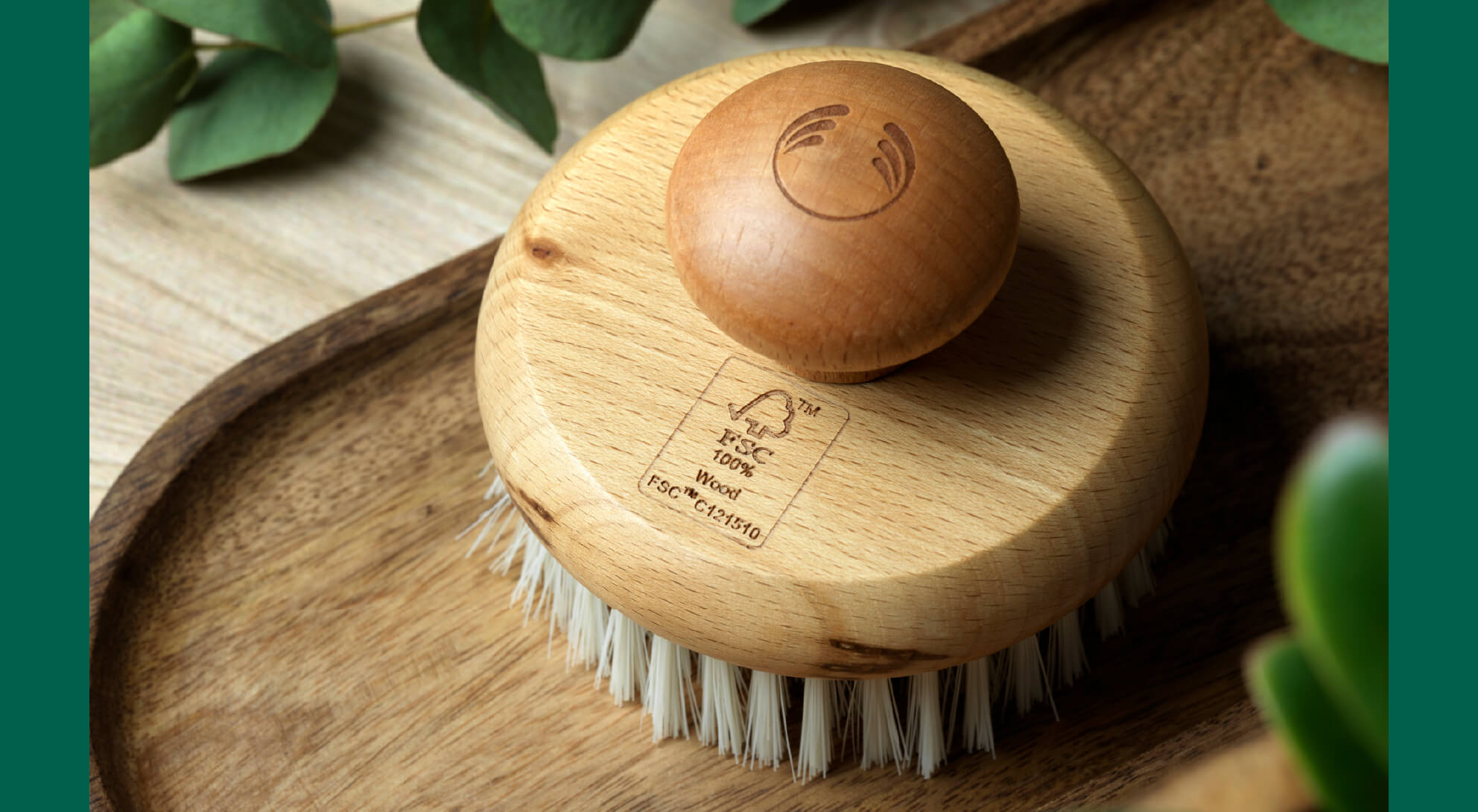 A close-up photo of a wooden dry brush shows the FSC certification engraved into the brush, signifying a type of sustainability certification. 