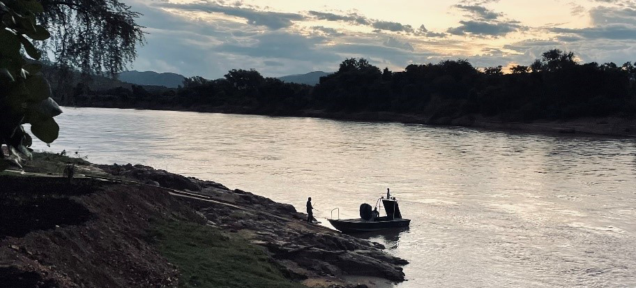 sunset on the Mbizi river where a small fishing boat is docked