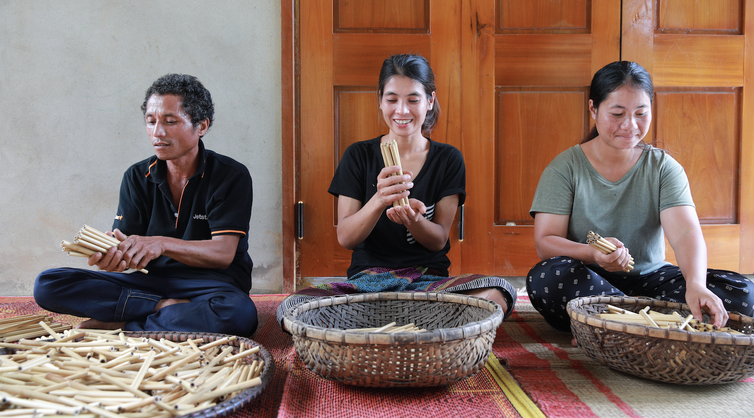 Three Vietnamese community members sorting bamboo shoots into three bowls