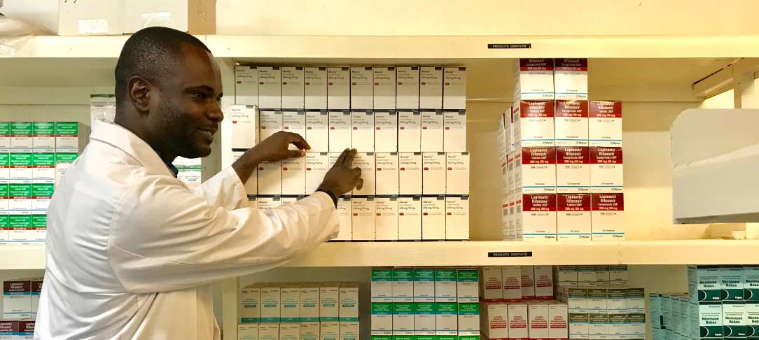 doctor standing next to shelves of boxed medication