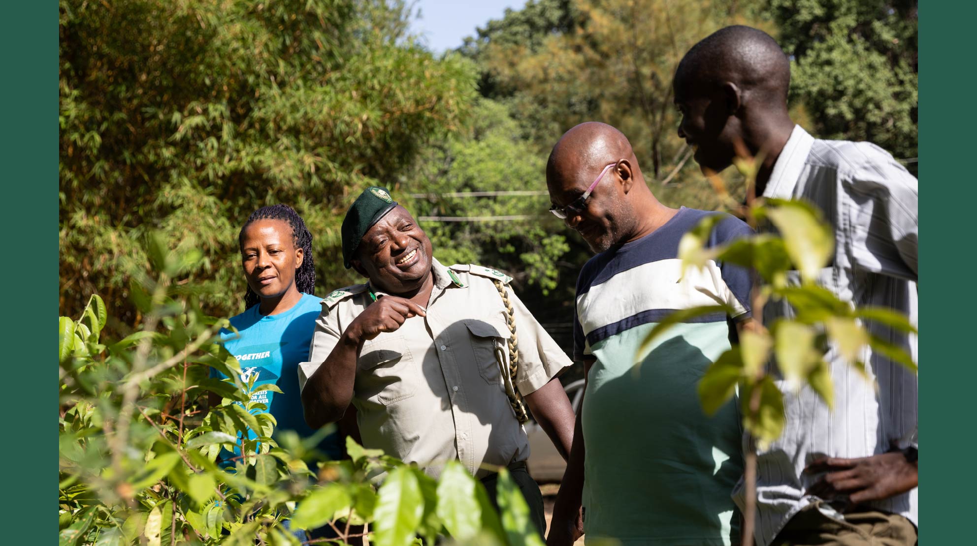 A group of four people standing outdoors smile while discussing ways to stand up to greenwashing. 