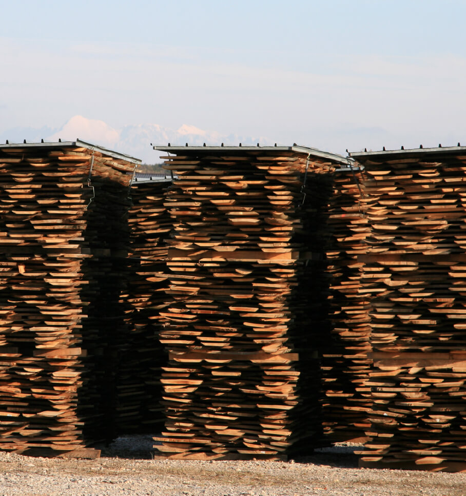 Large stacks of wooden pallets are shown at a lumber yard, representing the topic of sustainable supply chain certifications.