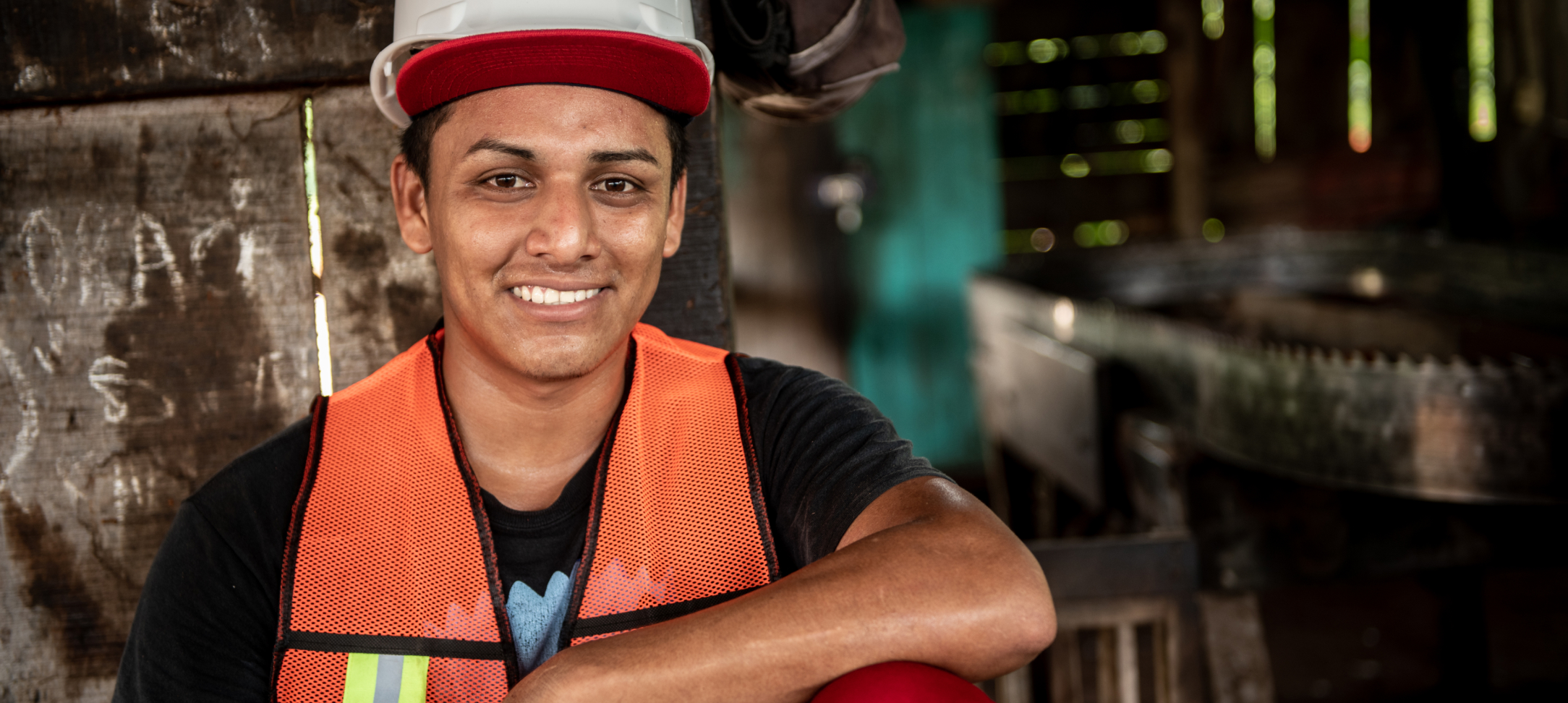 Worker smiling in a hard hat and safety vest