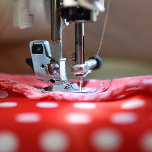 Sewing machine stitching red fabric