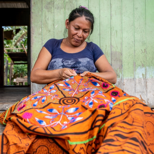 Woman stitching multicolored fabric