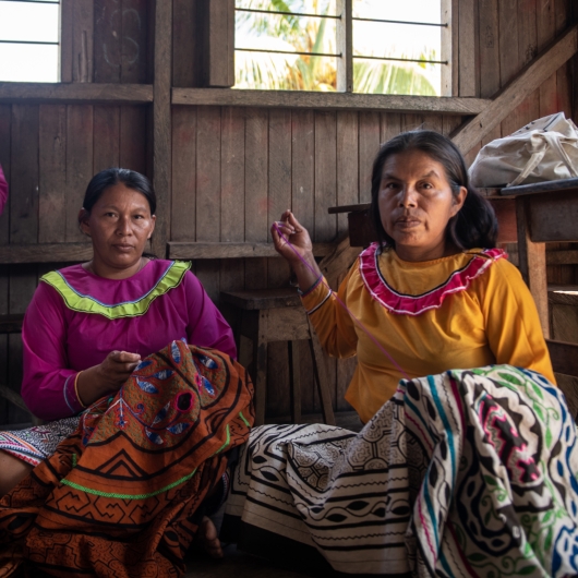 Two women sewing blankets