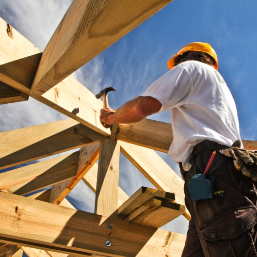 worker hammering a wooden foundation