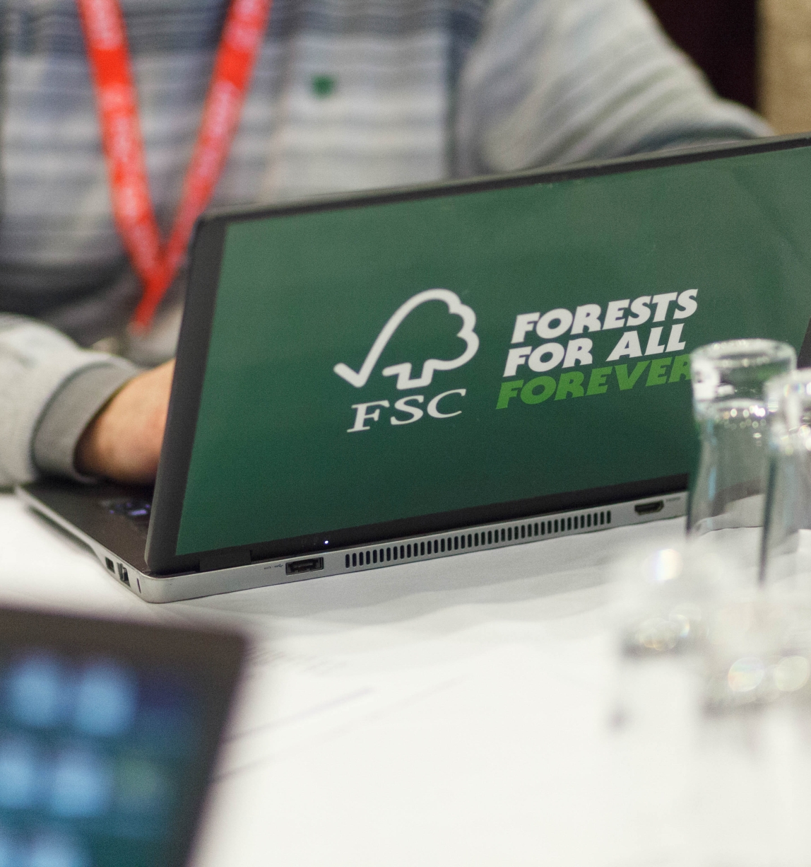 Person working on a laptop with a FSC sticker
