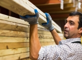 Man stacking wooden planks